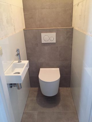 Vloertegel 30×60 cm Ariel Grijs betonlook NR12 op het toilet. Deze tegel is ook leverbaar in 60x60 cm en 80x80 cm.